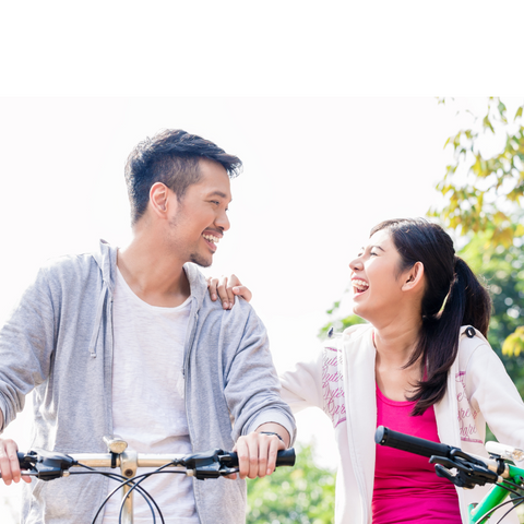 Love-&-Laughter-couple-riding-bikes-looking-at-each-other-laughing