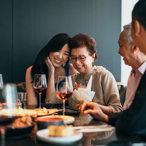 Mother's-Day-daughter-giving-mum-gift-with-family