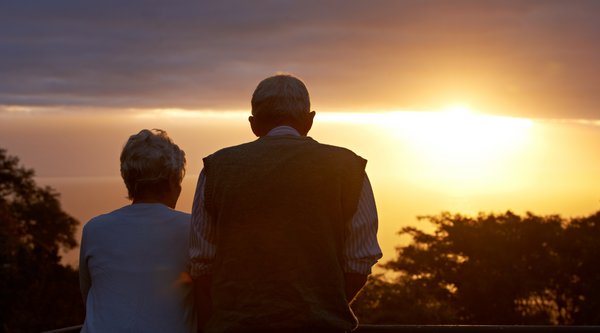 elder couple looking at sunset