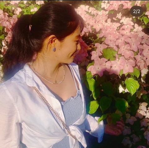 Lisa de Lisa's Garden debout regardant des fleurs roses dans un jardin