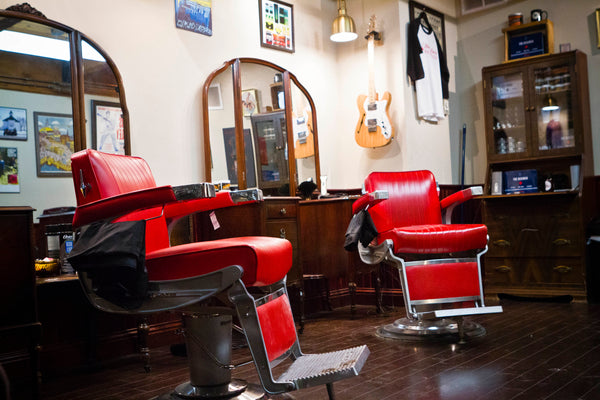 Un ensemble de chaises de barbier rouges dans la zone principale du Saint Lou's Barbershop
