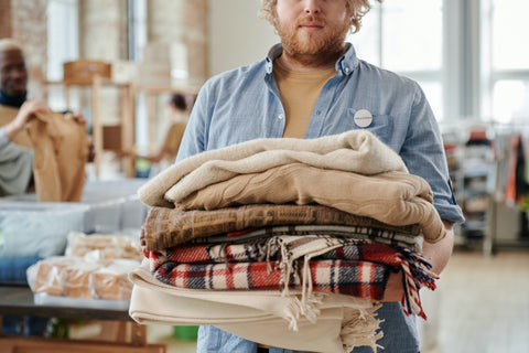 Man holding a pile of textiles