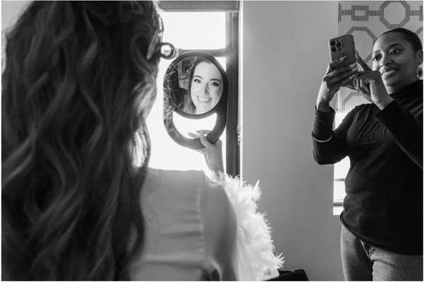 bride being photographed by a makeup artist. photo by Laura Leppert Photography
