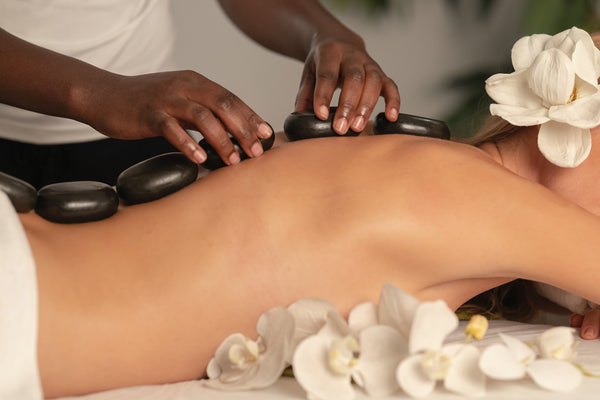 Aligning benefits to employee values - A person receiving a hot stone massage from a massage therapist.