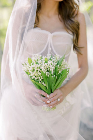 Bride holding lily of the valley bridal bouquet