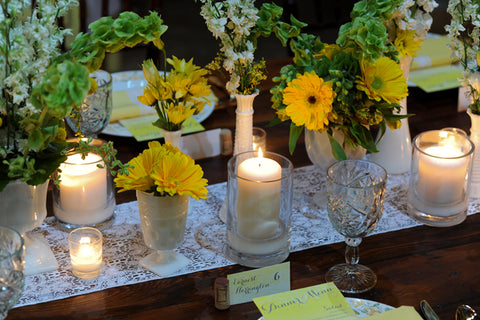 yellow flowers on table with candles