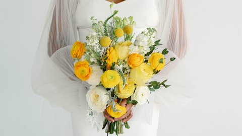 yellow and orange bridal bouquet being held by bride