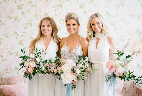 bride with her two maids of honor holding bouquets