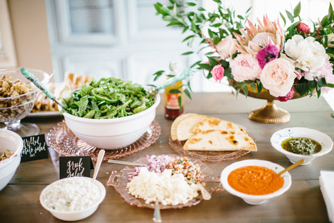 wooden table with food and a flower arrangement