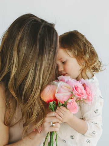mom and daughter holding pink and orange roses