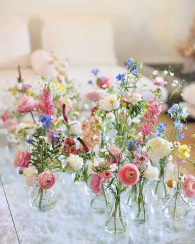 bud vases full of colorful flowers in clear bud vases