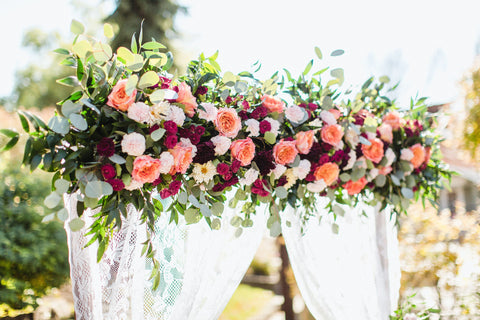 5 Reasons to Choose Roses Wedding Arch covered in various types of roses in multiple colors