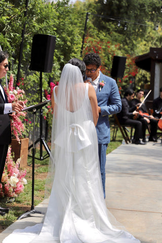 bride and groom at the alter, bride with bow on the back of her wedding dress