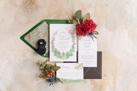 white wedding invites and red flowers flat lay