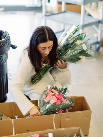 girl with black hair removing her flowers from a FiftyFlowers box