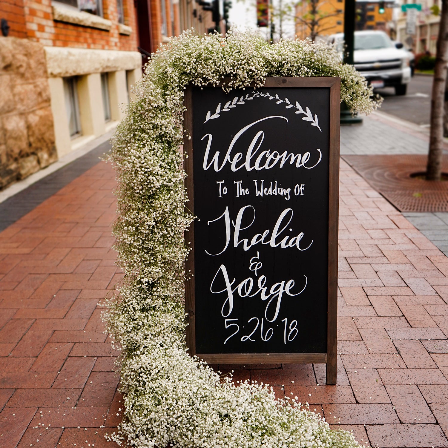 baby's breath garland wrapped around the side of a chalk board sign