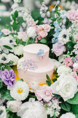 Barbiecore Wedding Inspiration Barbie pink cake surrounded by various flowers in shades of pink