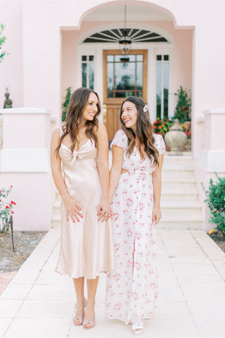 Barbiecore Wedding inspiration women/ best friends  in pink dresses at bridal shower in front of pink building