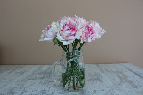 pink peonies in a clear mason jar with a handle