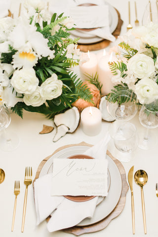 white table place setting with white flowers and coconut husks