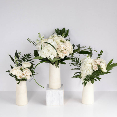 white and green table centerpieces in three white vases