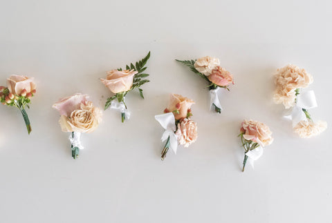 Seven light pink peachy colored boutonnieres