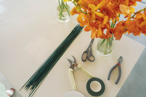 floral wire, floral shears, floral tape, and orange orchids