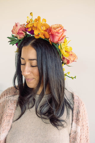 girl with black hair wearing completed orange and pink flower crown