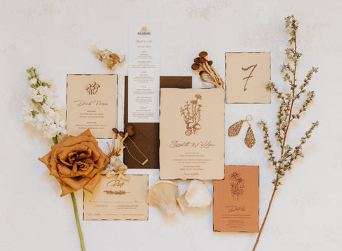 FiftyFlowers How To Style Toffee Roses and Possible Alternatives wedding flat lay with toffee roses, invitations, and dried florals