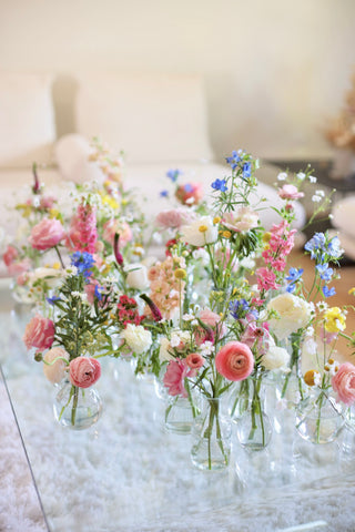 spring flowers in bud vases on a table