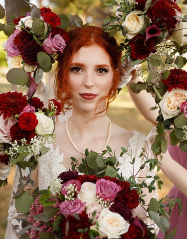 bride with red hair surrounded by bridesmaids bouquet flowers