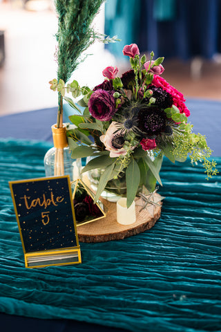 table centerpiece with pink, purple, and white flowers with a table number