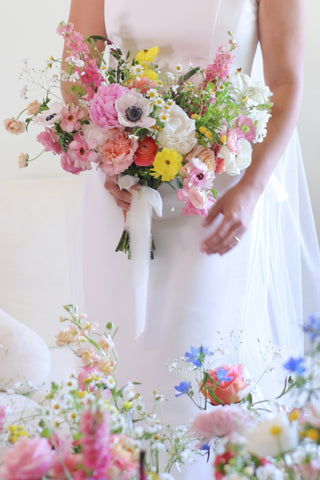 bride holding bridal bouquet that features colorful flowers