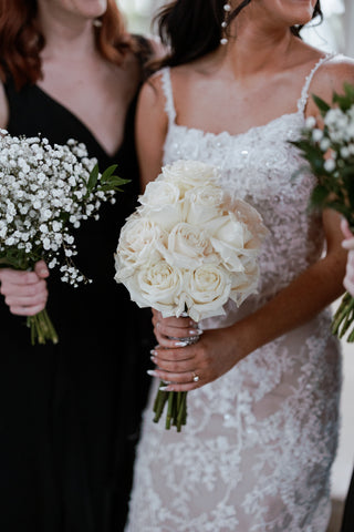 bride with brides maid holding white roses and white baby's breath