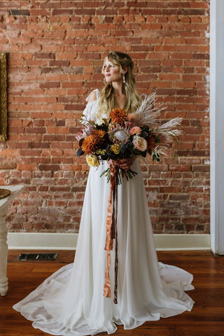 bride showing off dress and bridal bouquet