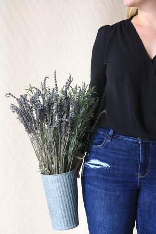 woman holding metal bucket full of lavender