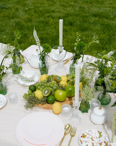 Picnic set up with Moss Green Flowers and limes, lemons, grapes, and kiwis