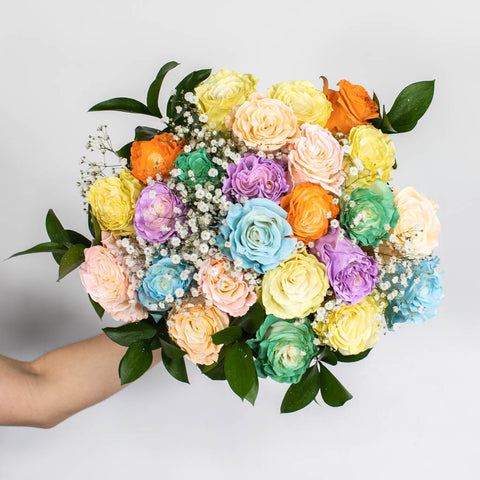 Rainbow pastel tinted roses in a bouquet held in hand