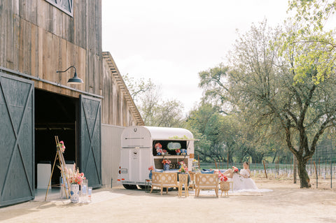 rustic wedding with bride on couch outside of a barn