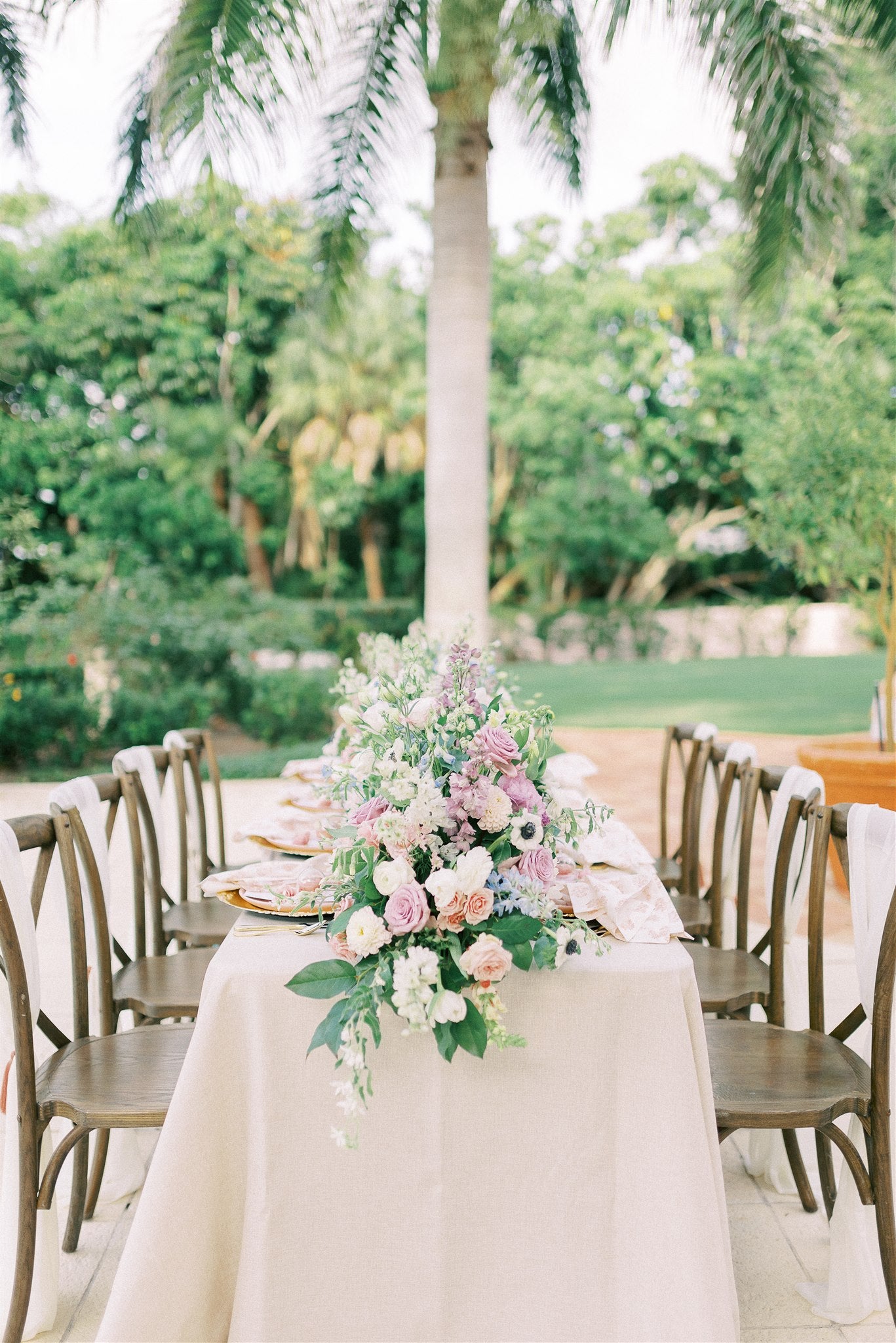 pink, purple, and white flower arrangements as a table centerpiece outside
