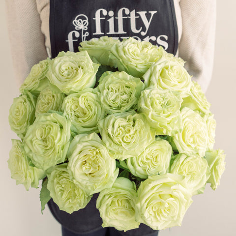 green tea roses held by person wearing a fiftyflowers apron