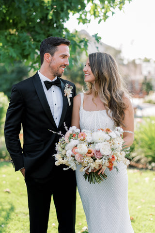Wedding couple with bridal bouquet featuring Feverfew Daisies