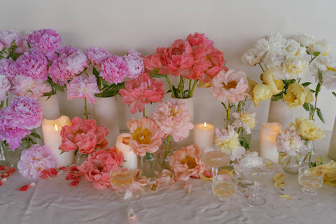 peony centerpiece with pink, hot pink, and white peonies on a table with candles for valentines day
