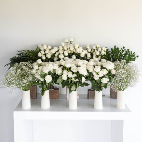 ten vases with roses, baby's breath, and ruscus