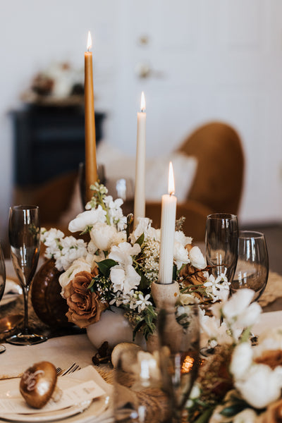 tan and white flower table centerpieces with tall slim candles