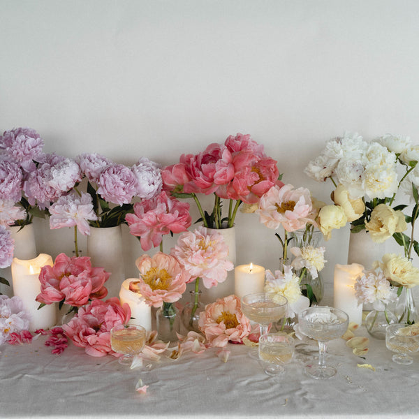 tablescape with pink, purple, and white flowers featuring lit candles