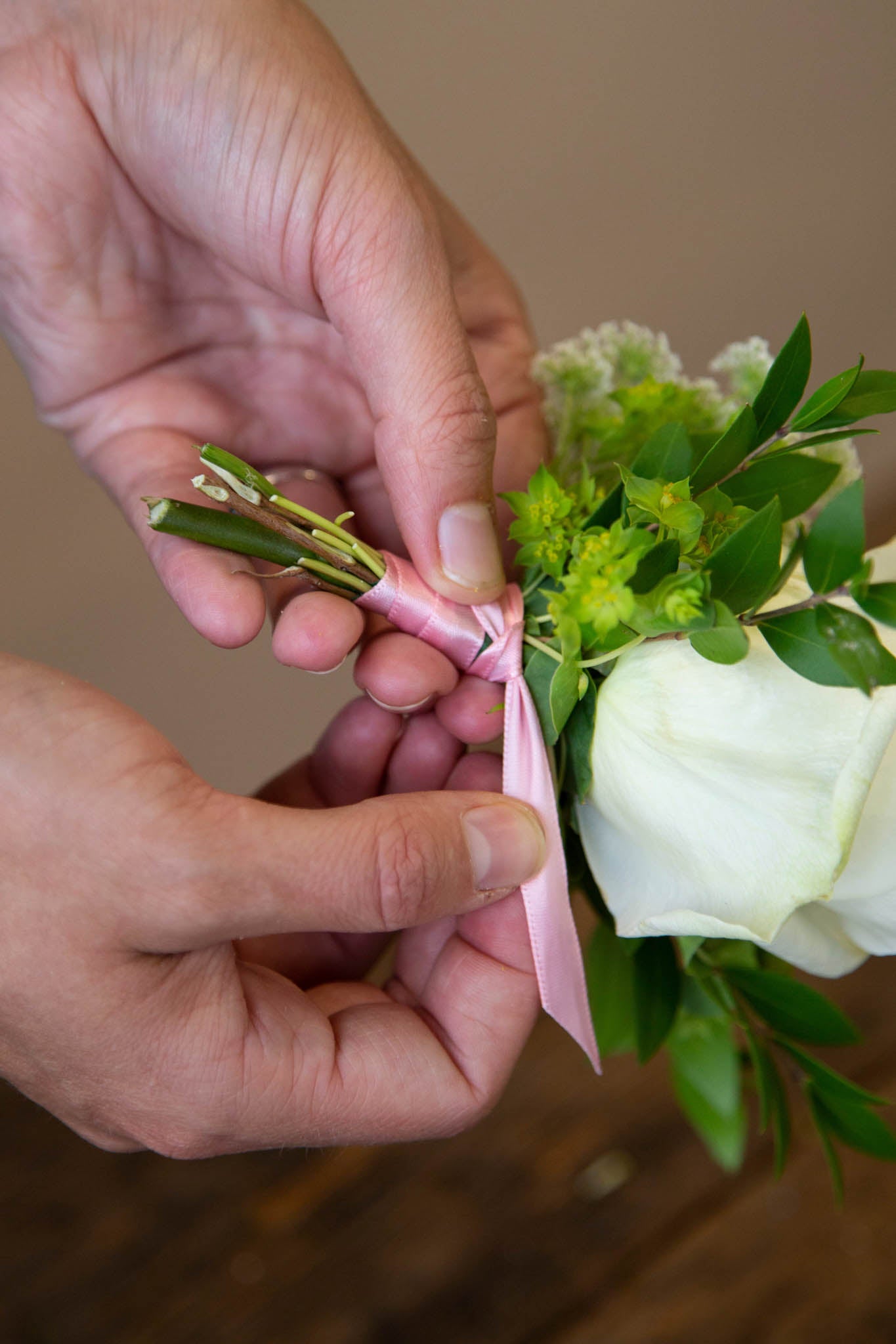 Finish your DIY boutonniere by wrapping the stems and tape in ribbon