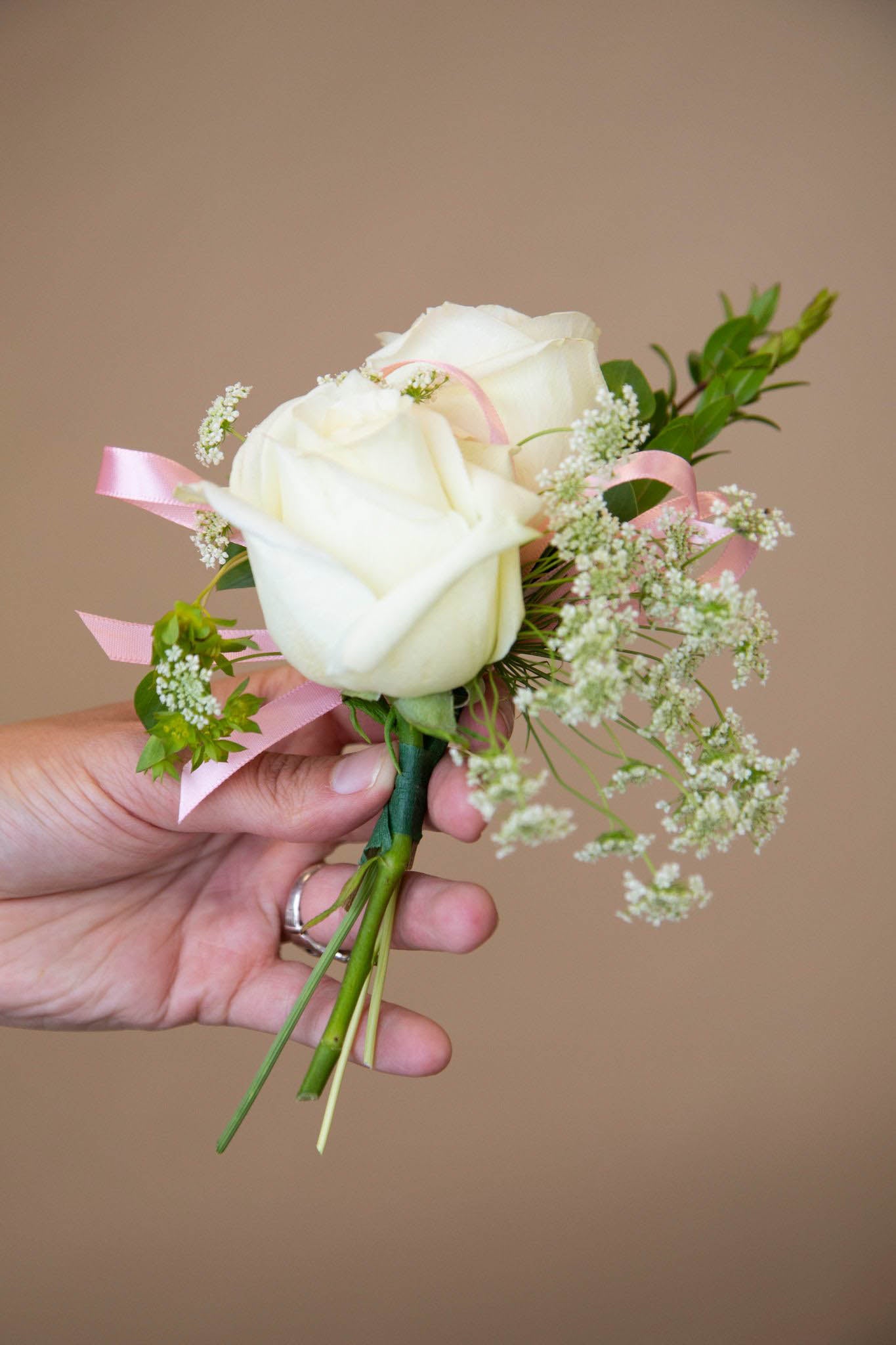 Continue adding filler flowers, focal flowers, and greenery until you are satisfied with your DIY corsage