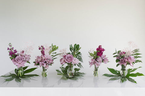 five small purple arrangements in a line