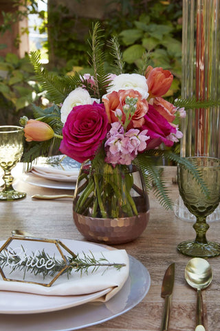 clear and gold dipped vase on a wooden table with pink and white flowers